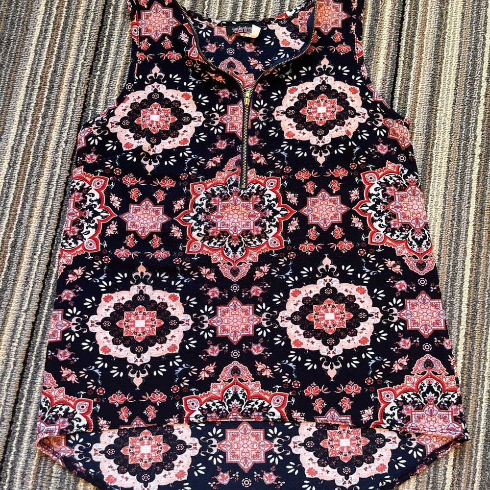 Lightweight polyester sleeveless with long tail in back and zipper front.